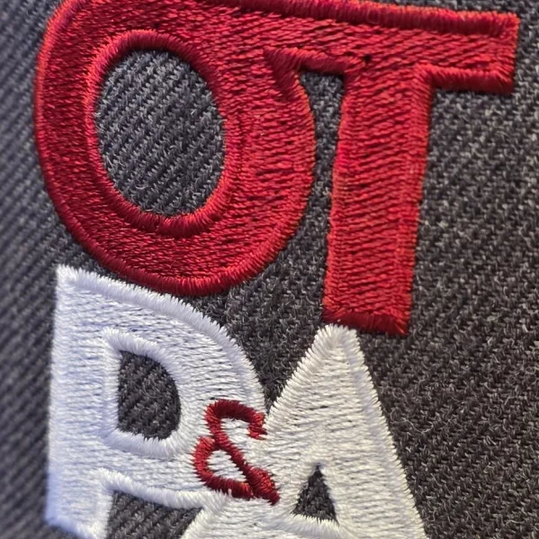 Close-up of red and white direct embroidery on a heather gray cap