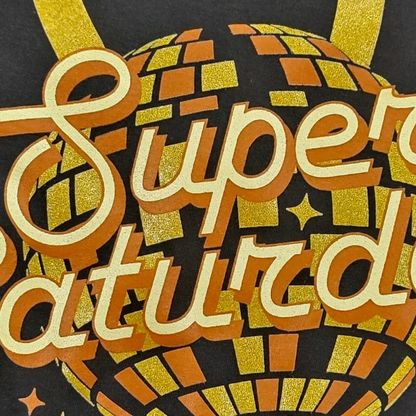 Close-up of a gold and orange screen print with shimmer ink on a black t-shirt