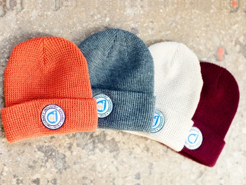 Four knit cuffed beanies with round Craft Industry Apparel woven patches